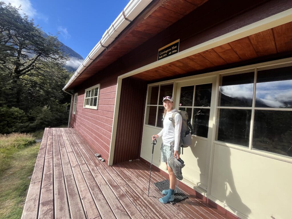 A photo outside of a hut in New Zealand, with the founder of Heywood's Backpack Adventures